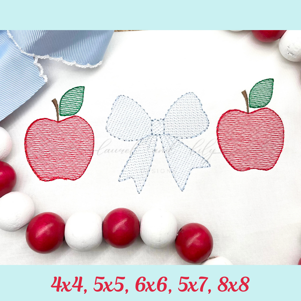 Embroidery designs of apples and a bow on fabric with red, white, and blue threads.