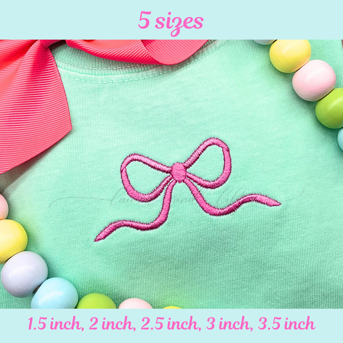 Embroidered pink bow on a green fabric background with colorful beads and ribbons.